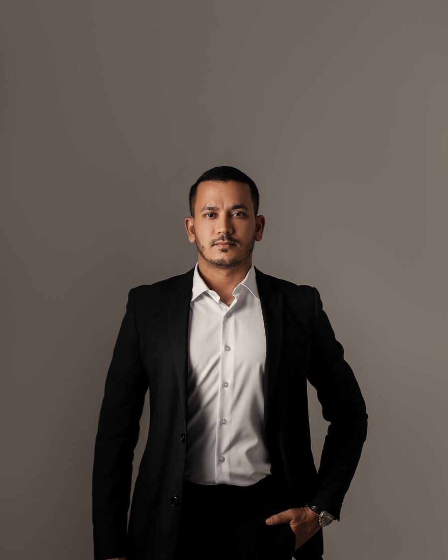Dr. Danilo Henrique em pé, de terno escuro e camisa branca